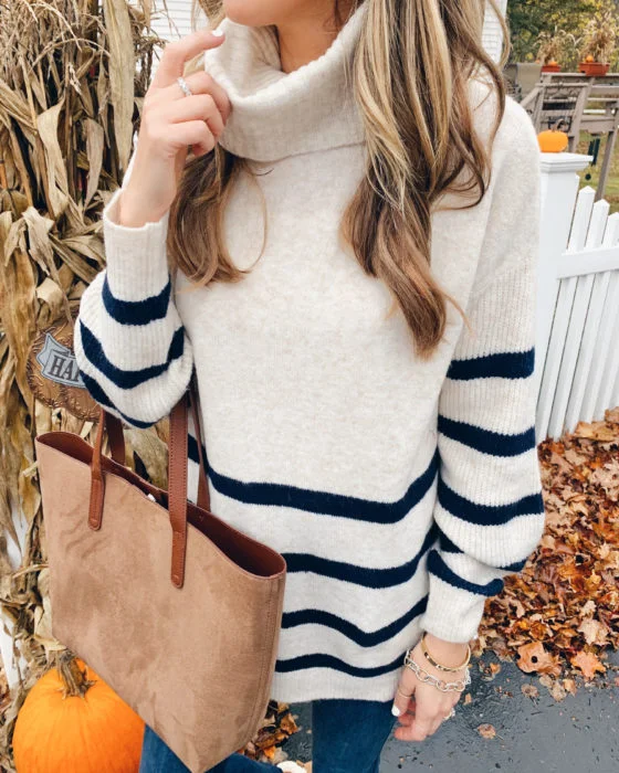 Thanksgiving sweater outfit: cream striped turtleneck with tan tote and jeans