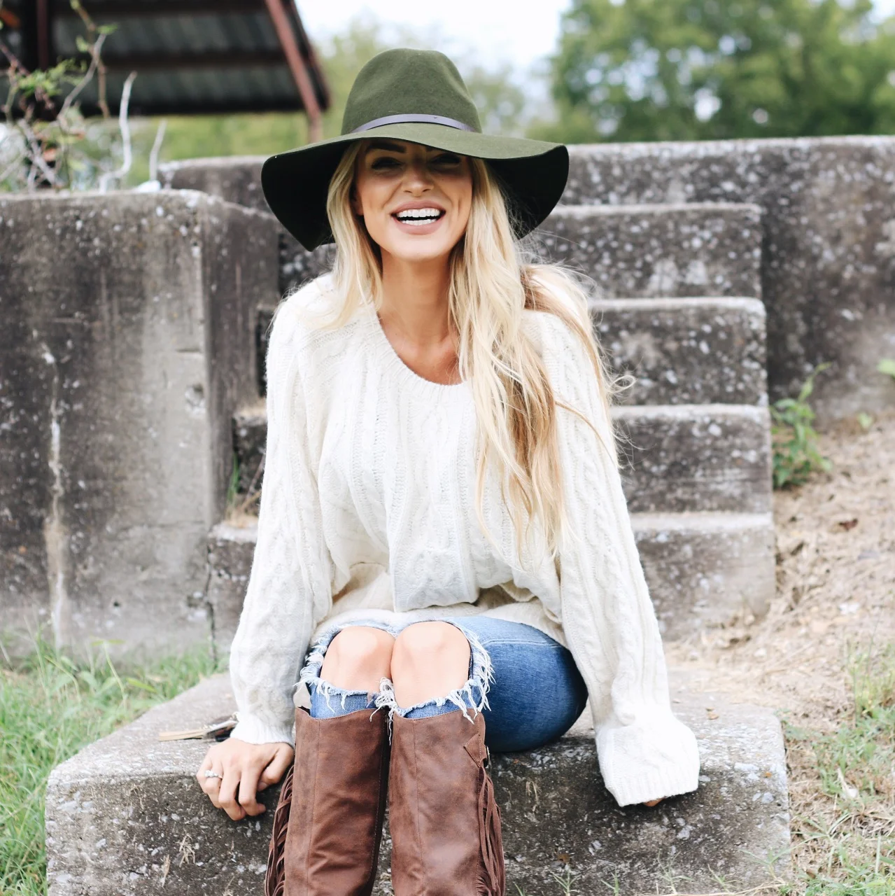 Thanksgiving sweater outfit: white cable knit sweater with brown boots and hat