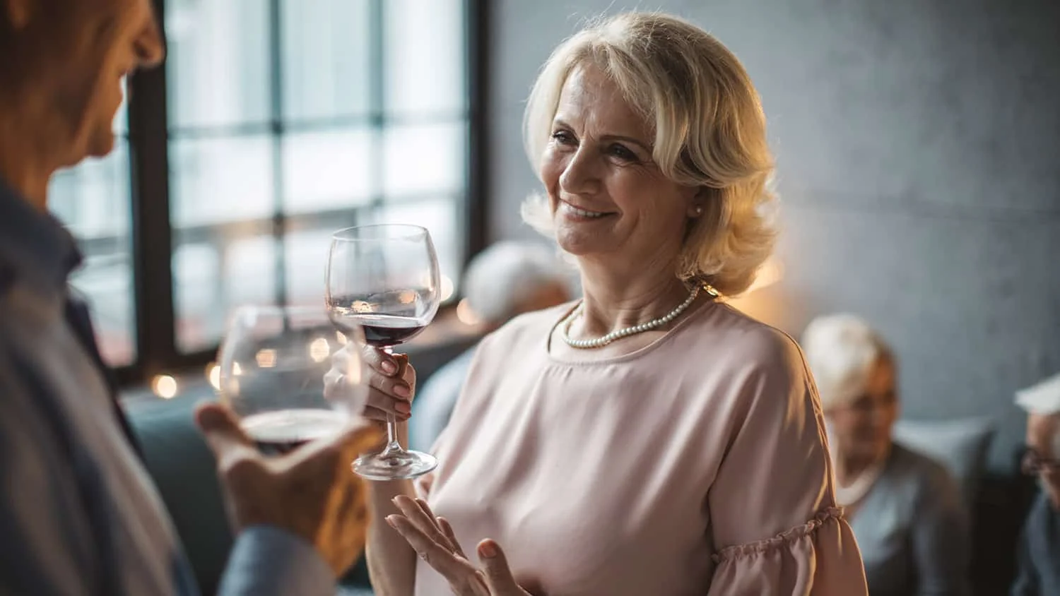 Blush pink top with wine glass at dinner