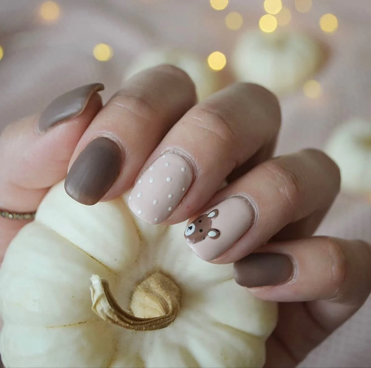 Easy fall nail ideas: gray matte nails with tiny pumpkin art