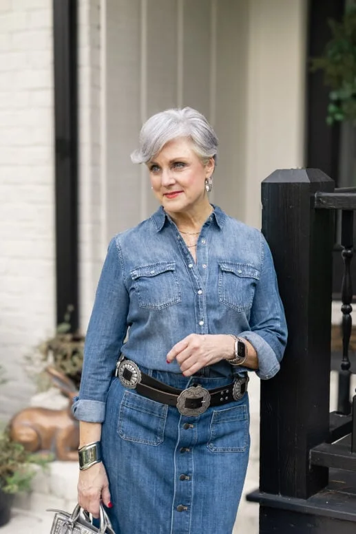 Mature woman in denim jacket over beige dress