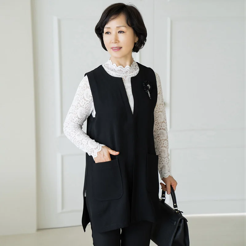 Mature woman in black vest over white lace blouse