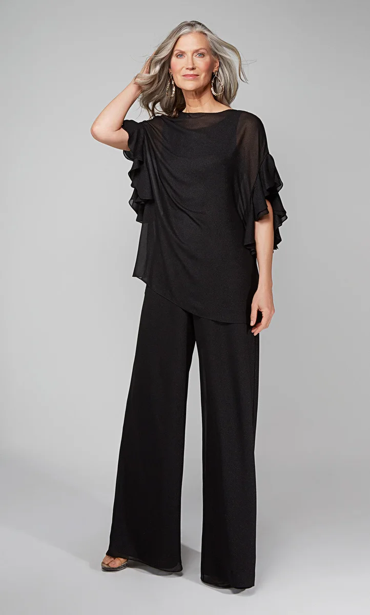 Mature woman in black draped top and wide leg pants