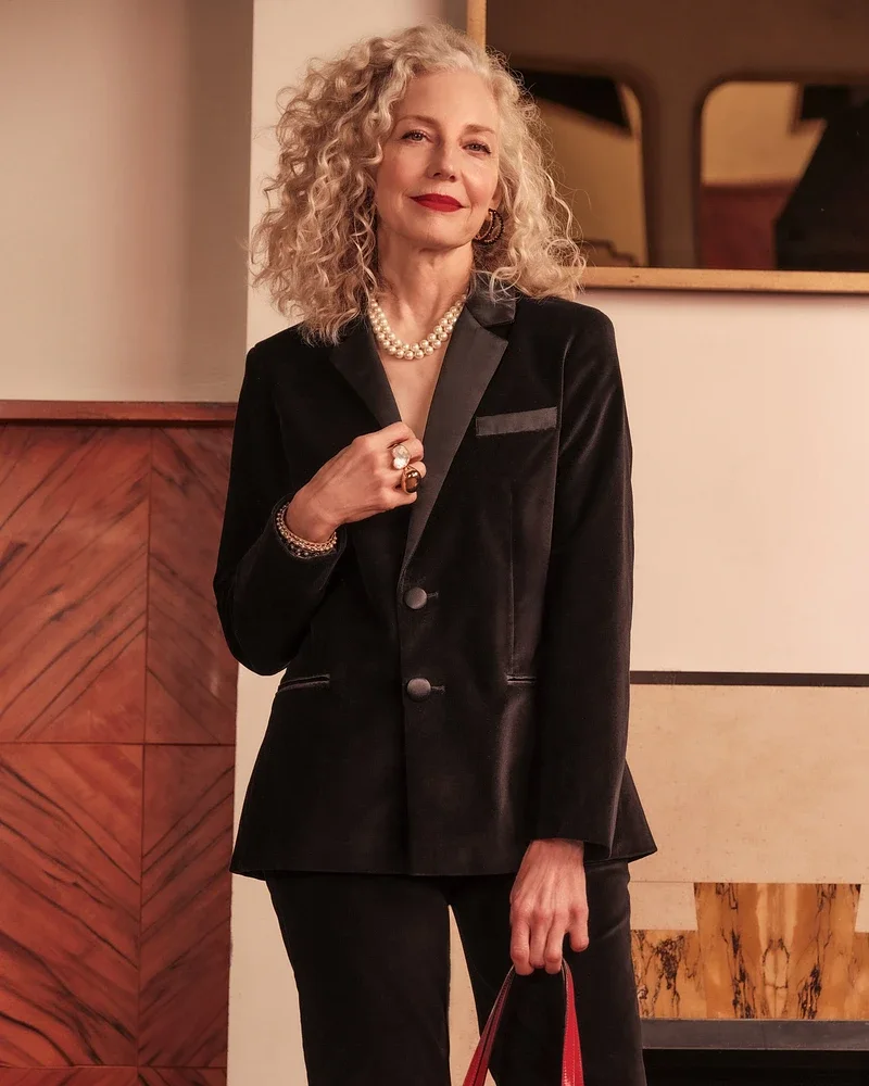 Mature woman in black velvet blazer with pearl necklace