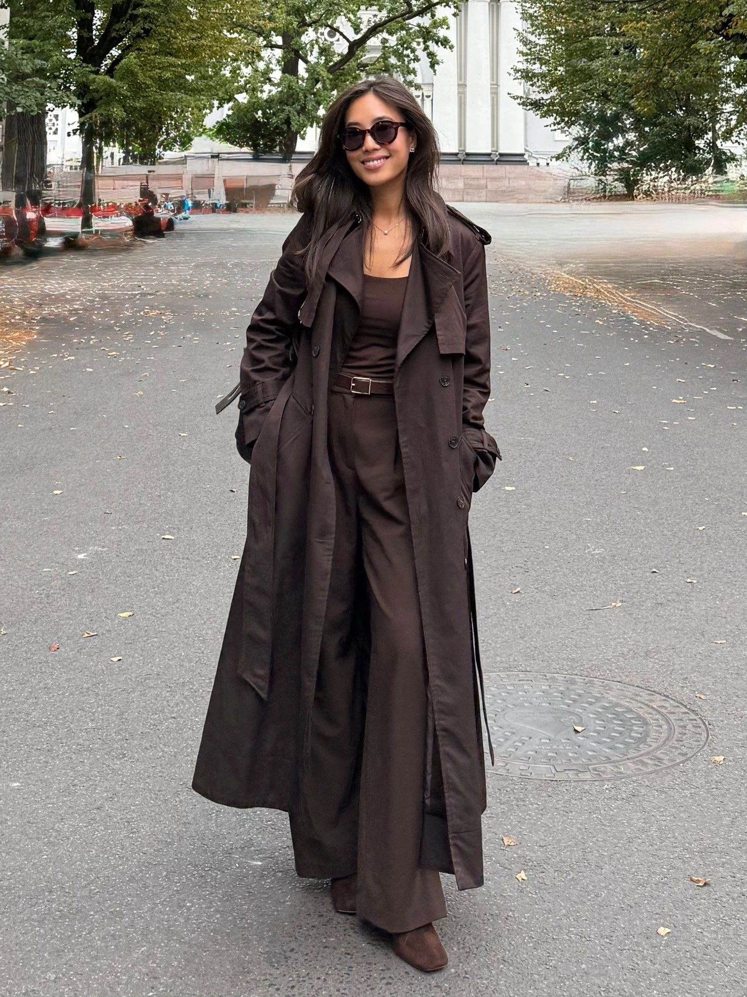 Fall rainy day outfit: long dark brown coat worn over a simple dress