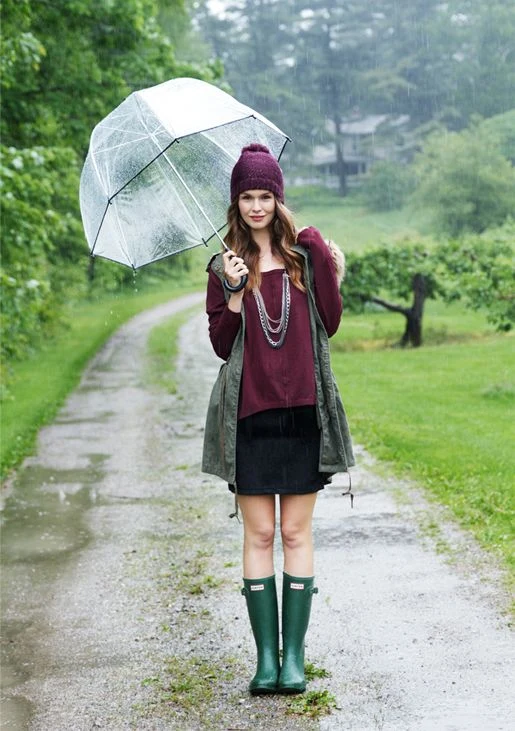 Fall rainy day outfit: clear umbrella with green rain boots and a burgundy top