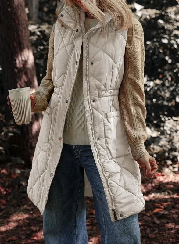 Plus size fall game day outfit: long cream quilted vest over dark top with jeans