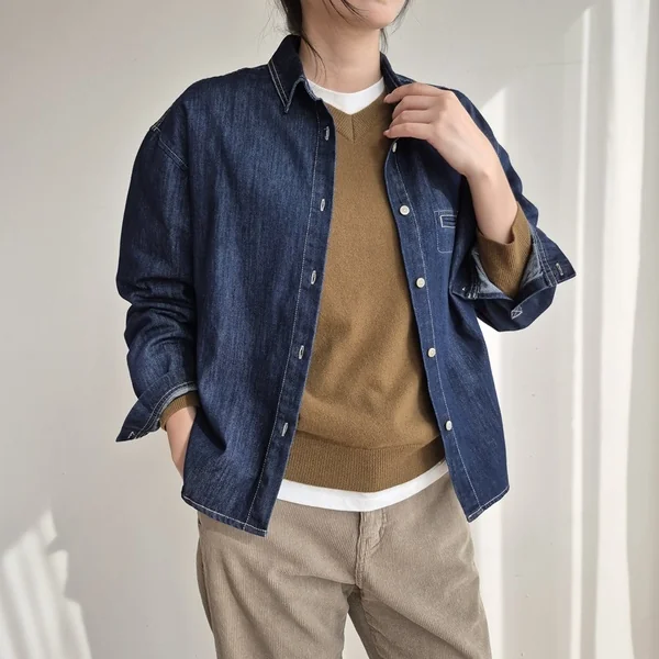 Plus size fall game day outfit: denim shirt layered under a mustard sweater