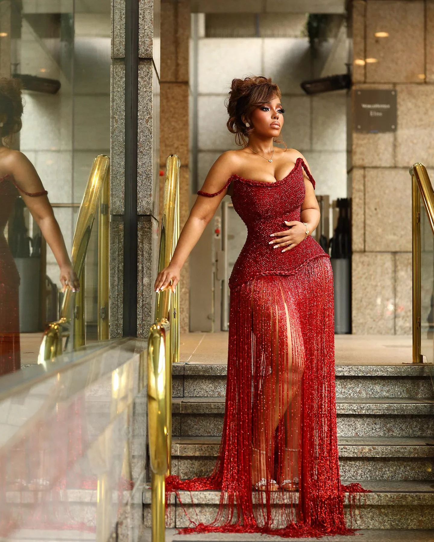 Red sheer embellished evening gown on a staircase
