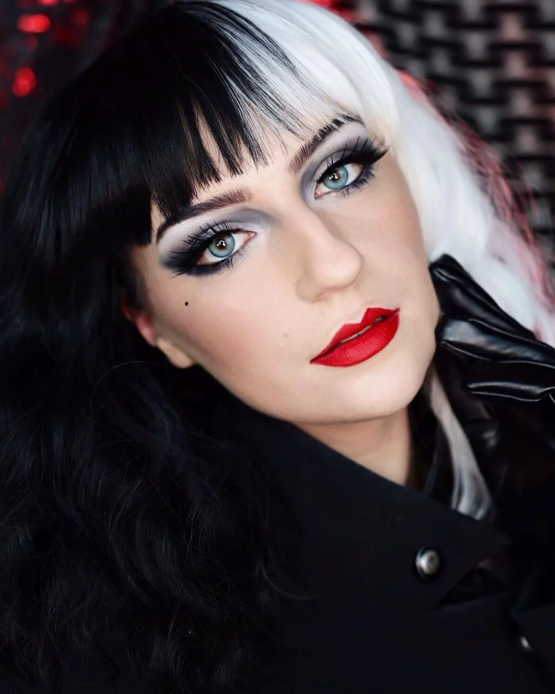 Cruella glam makeup with black and white wig and red lips