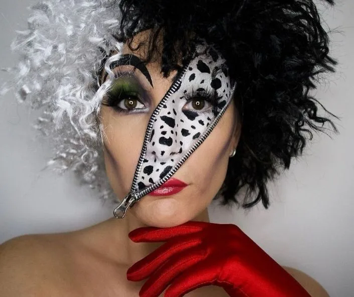 Split face Cruella skull makeup with dalmatian spots and zipper teeth