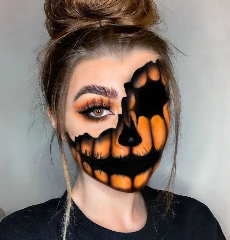 Half pumpkin half glam face paint with carved orange grin