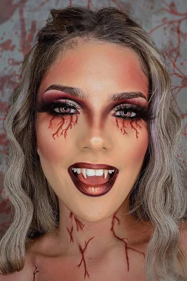 Bleeding crack vampire makeup with red veins and fangs
