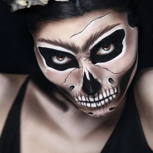 Bold black skull makeup with deep sockets and cracked forehead