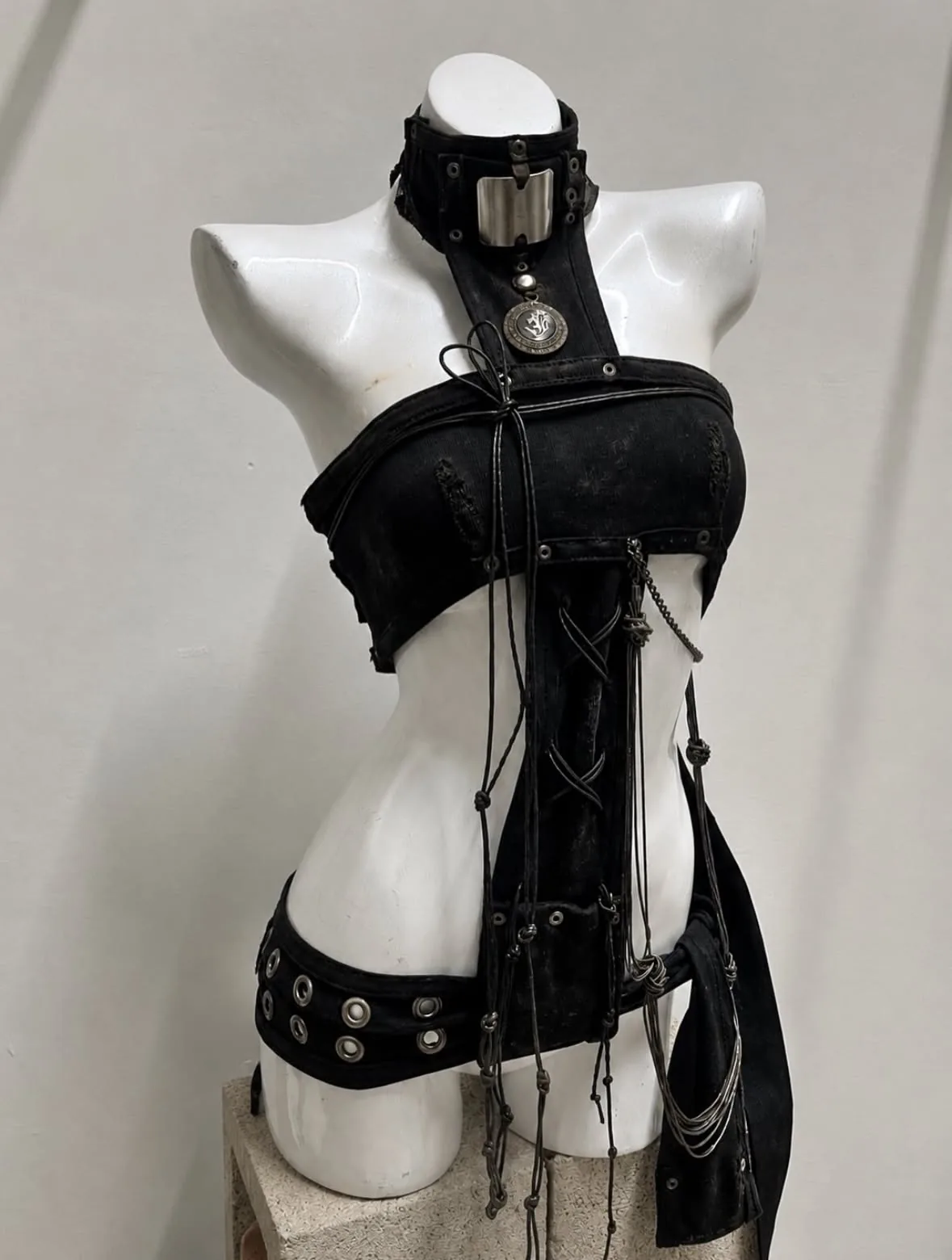 III points festival outfit: black bondage-style harness top and choker on a dress form