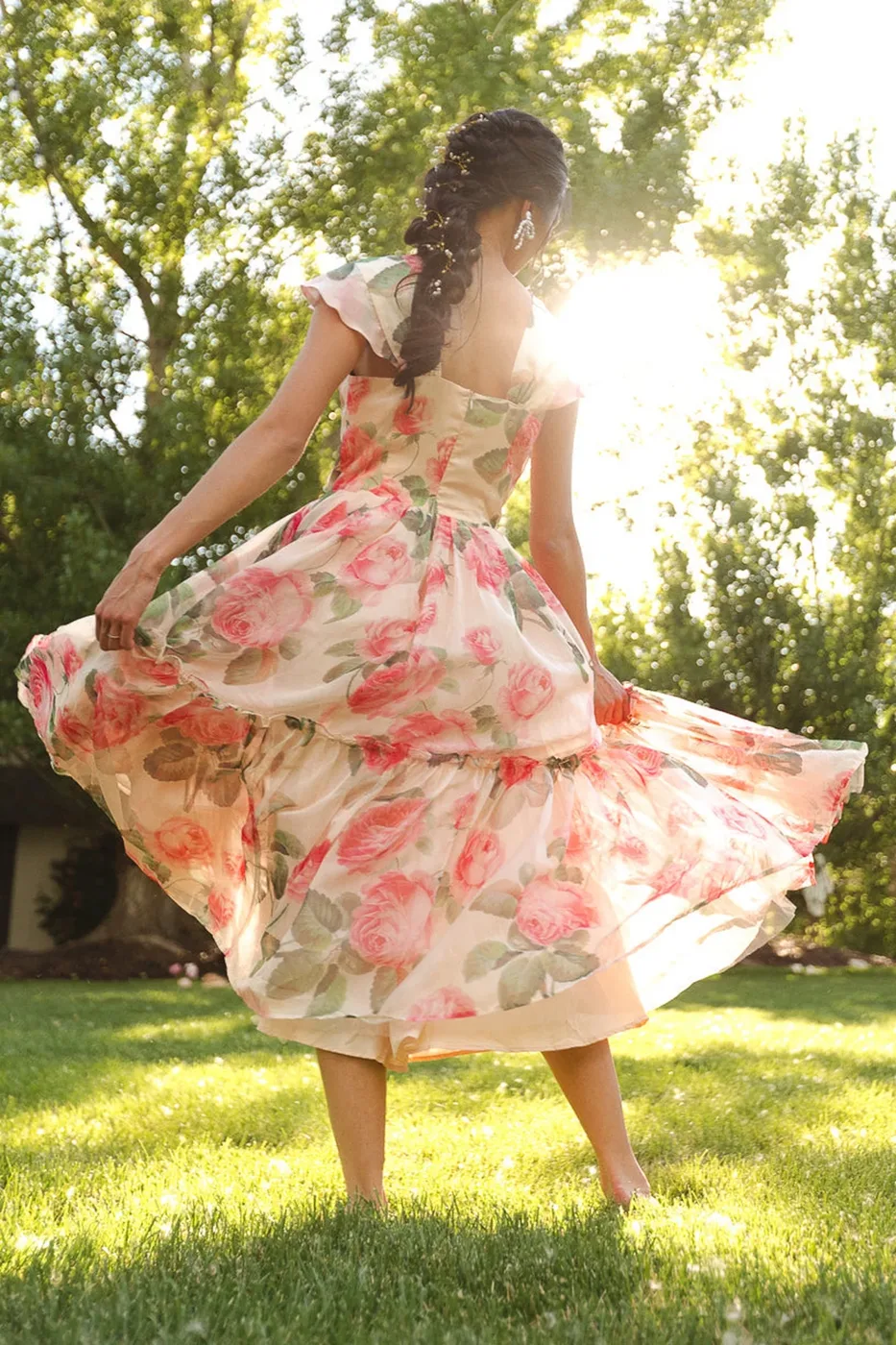 Rose print tiered midi dress twirling in sunny garden