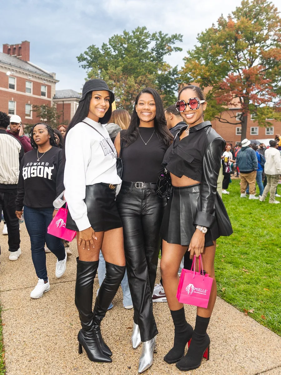 Group of four Black women in black and white outfits with boots at homecoming