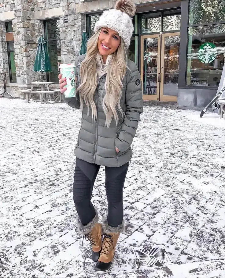 Woman in a gray puffer jacket, beanie and duck boots in the snow