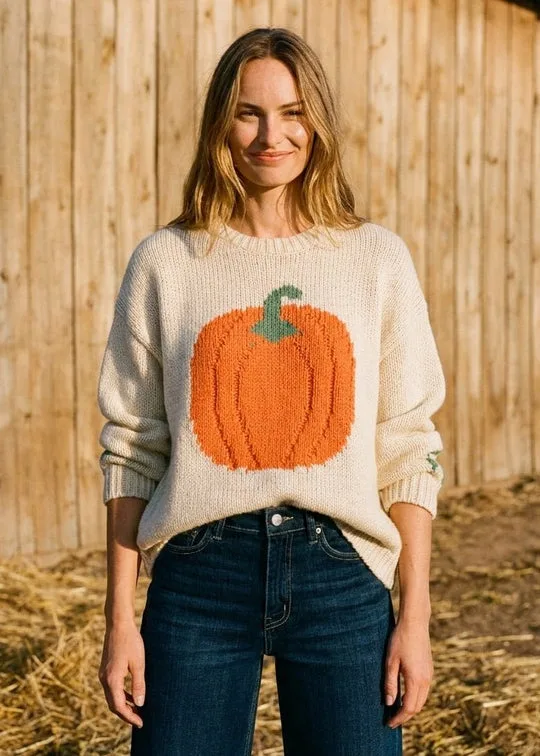 Cream pumpkin sweater with a large orange pumpkin motif and jeans