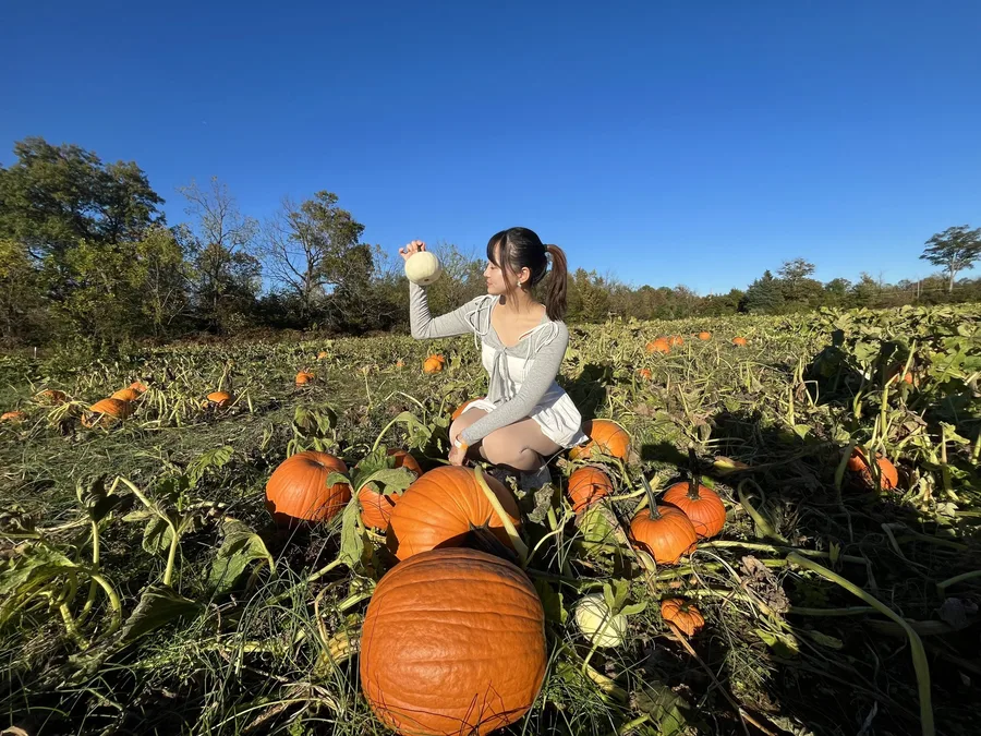 Pumpkin patch outfit: white mini dress crouching among the vines