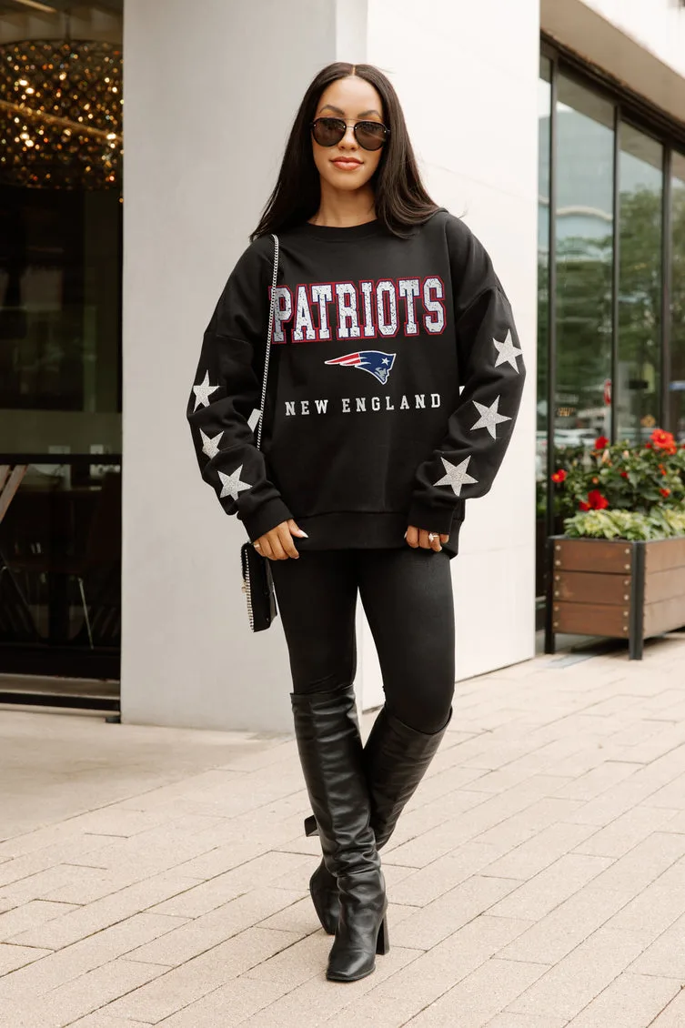 Woman in black Patriots sweatshirt, black leggings and boots