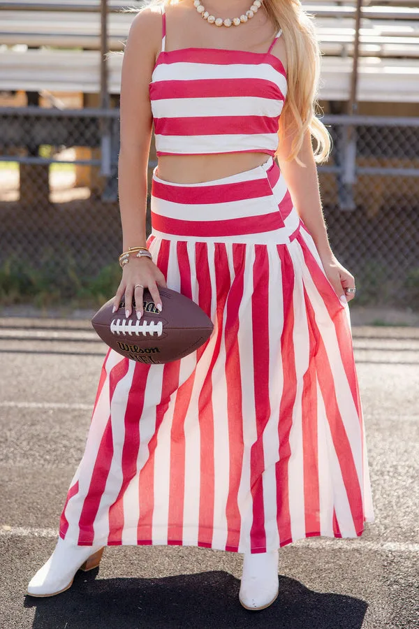 Woman in red and white striped matching set holding a football