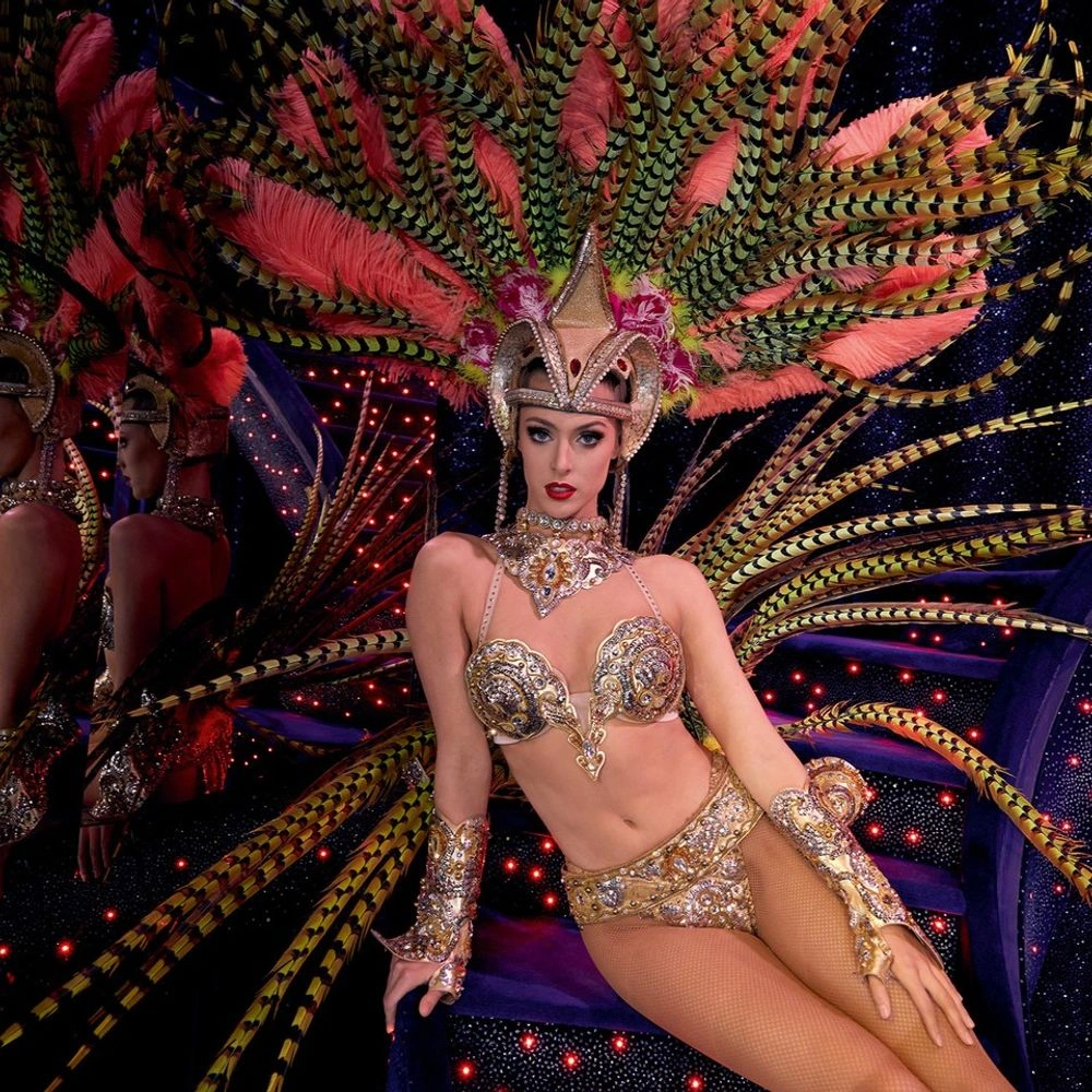 Woman showgirl with large pink and green feather backpiece