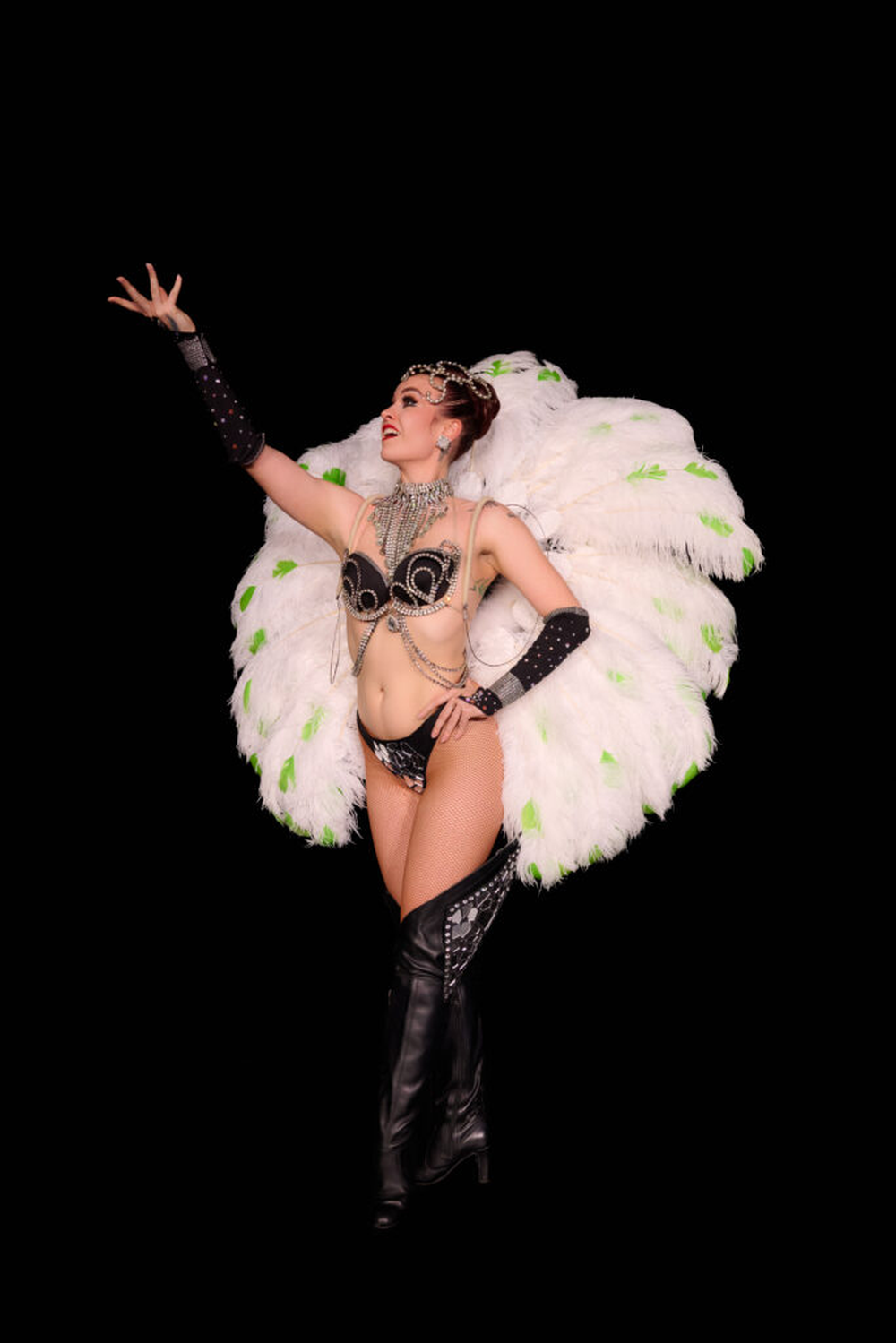 Woman in black showgirl costume with feather accessories
