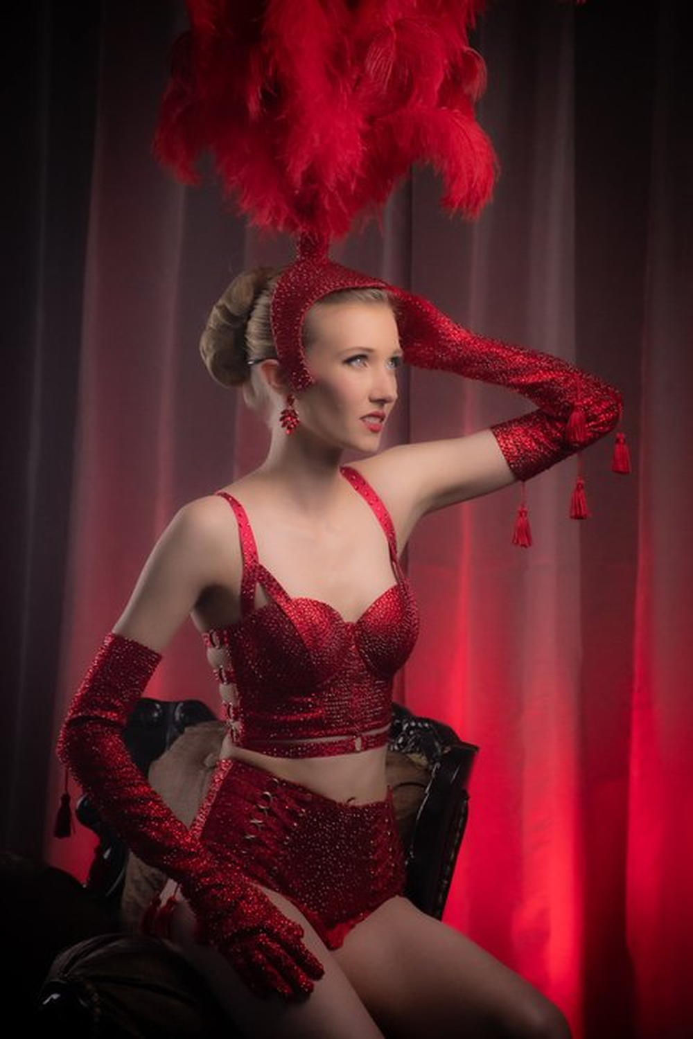 Woman in red cabaret showgirl costume with feather headpiece