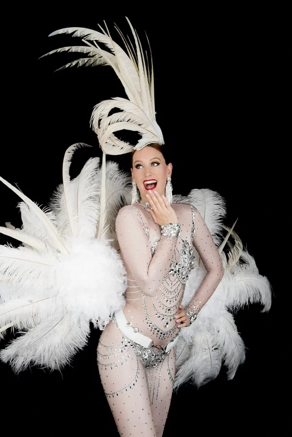 Showgirl in white feather costume with tall headpiece