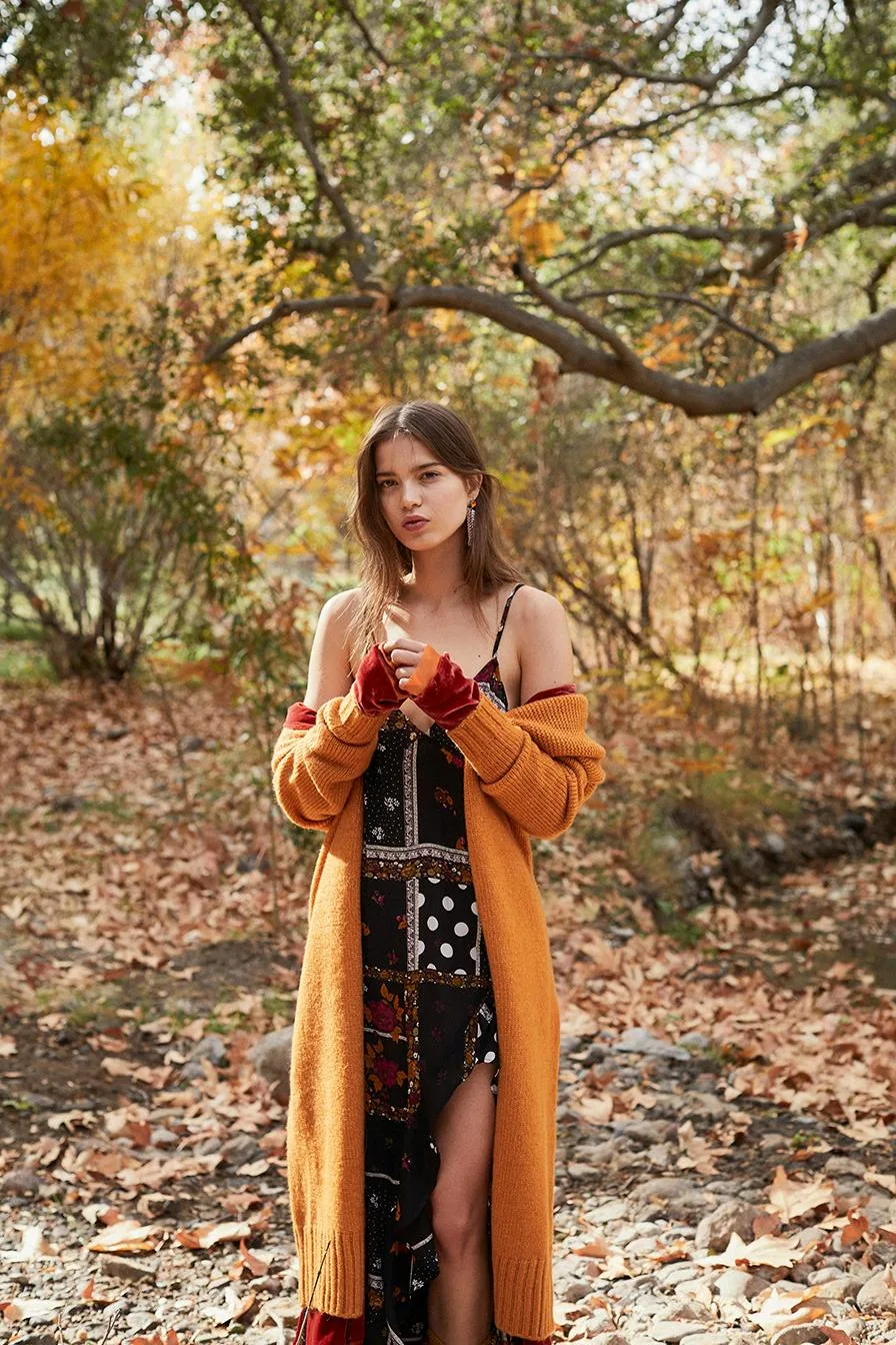 Long rust cardigan over dark floral maxi dress in autumn woods, romantic fall date night outfit