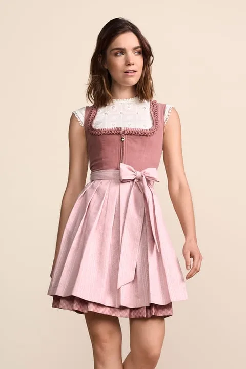 Woman in a blush pink dirndl with a white lace blouse