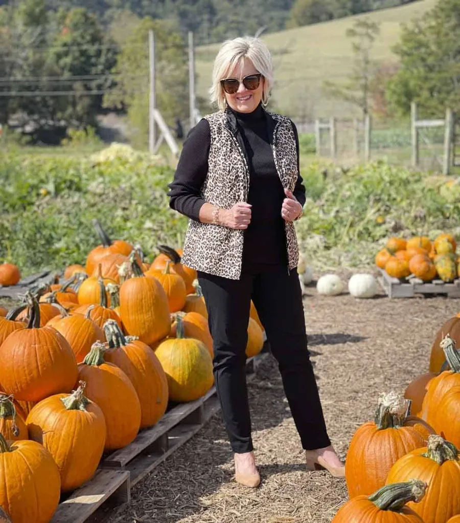 Pumpkin patch outfit for older women: black top with a patterned vest