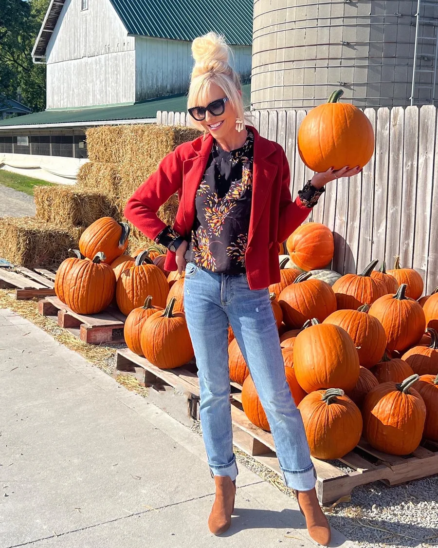 Pumpkin patch outfit: red jacket with jeans holding a pumpkin