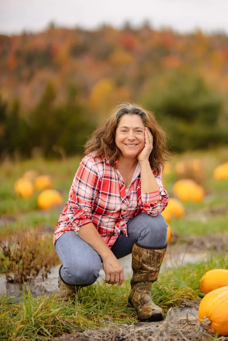 Pumpkin patch outfit: red plaid shirt crouching among the pumpkins
