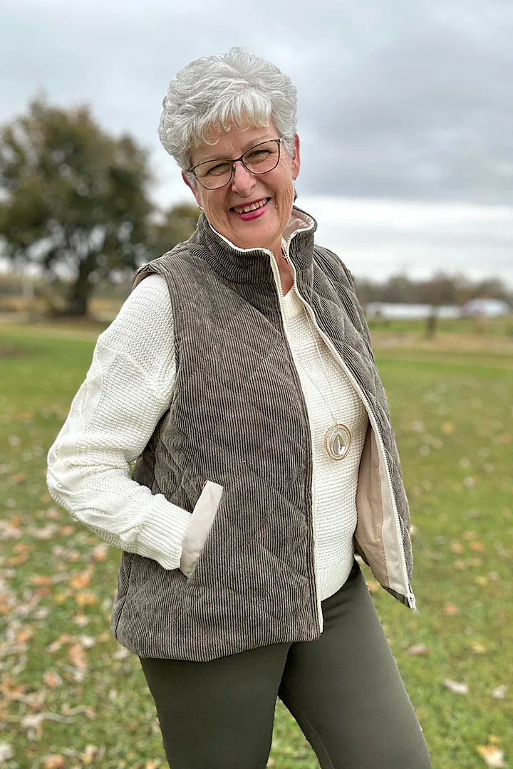 Pumpkin patch outfit for women over 50: quilted vest with a white sweater