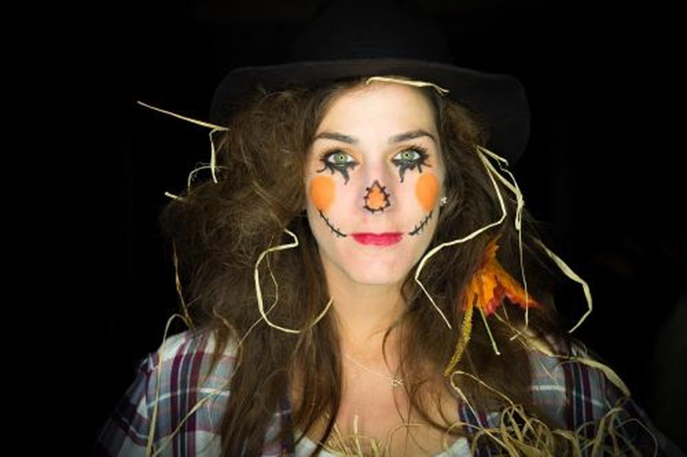 Woman in scarecrow costume with straw hat