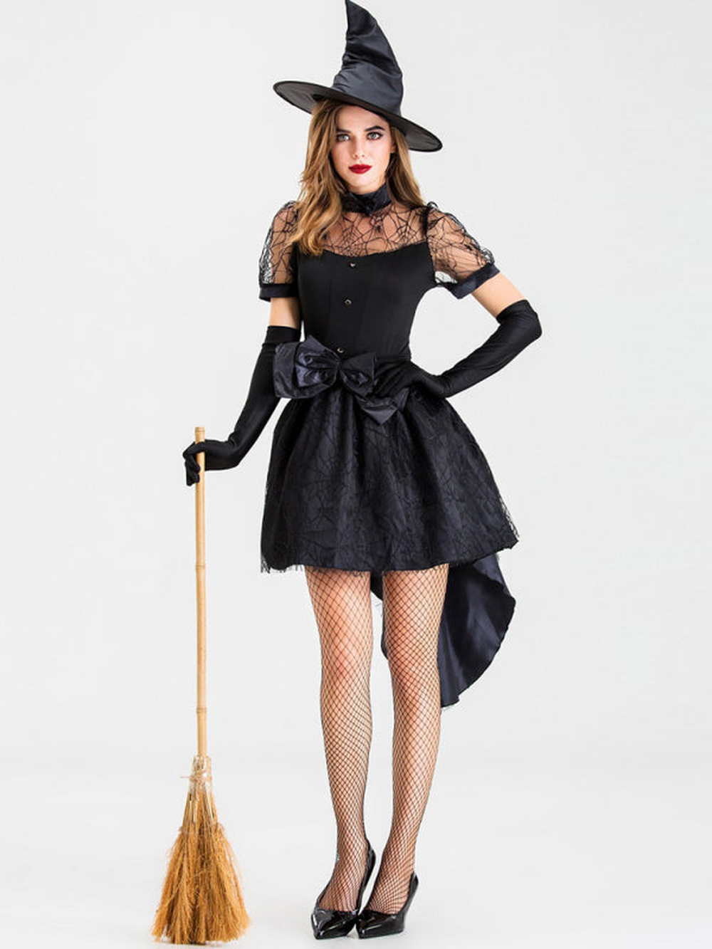 Woman in black witch costume with hat holding broom