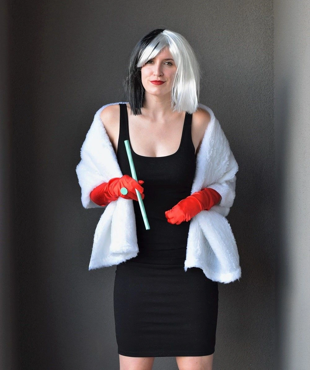 Woman in Cruella de Vil costume with black dress and white fur stole