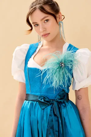 Young woman in a turquoise dirndl with a feather detail
