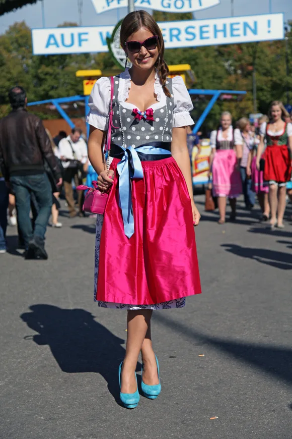 Young woman in a pink dirndl with turquoise heels at Oktoberfest