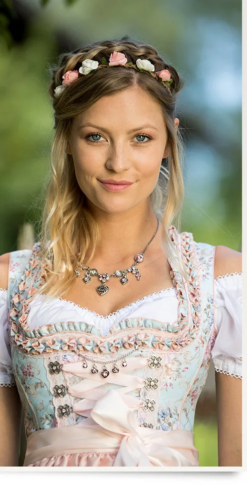 Young woman in a pink dirndl with a flower crown and necklace