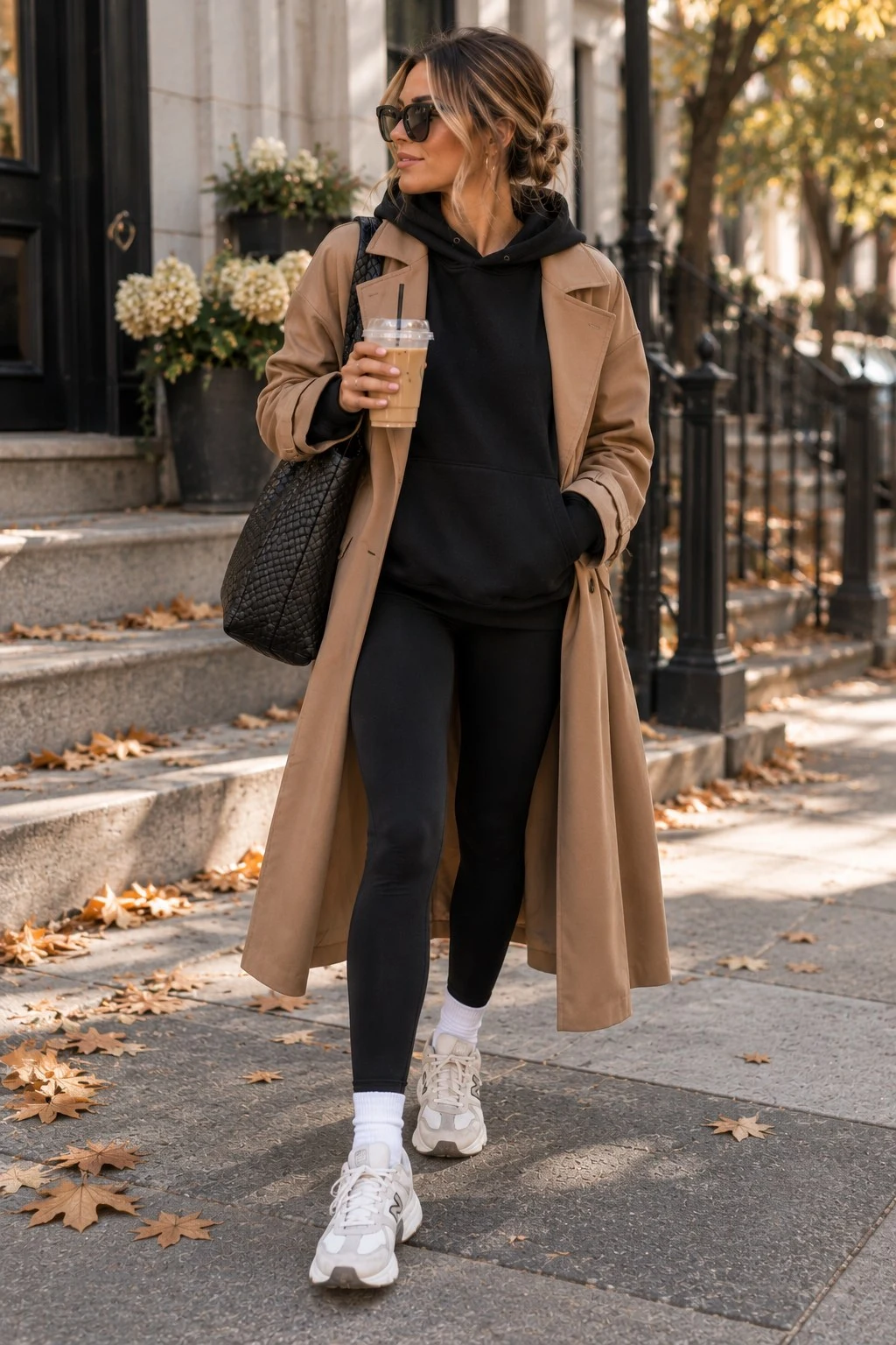 Camel coat over black leggings and sneakers street outfit