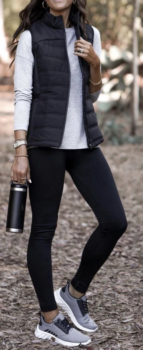 Black quilted puffer vest with black leggings and sneakers
