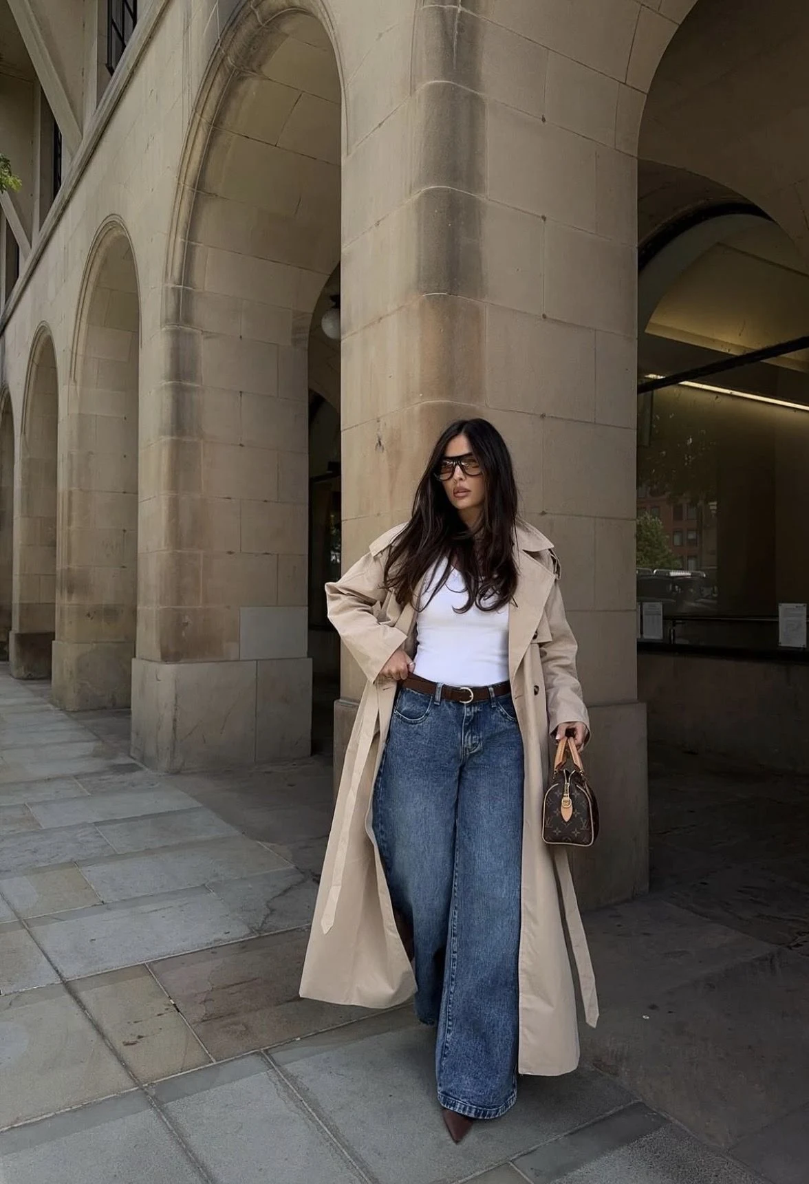 Woman wearing wide-leg jeans with platform boots and a trench coat