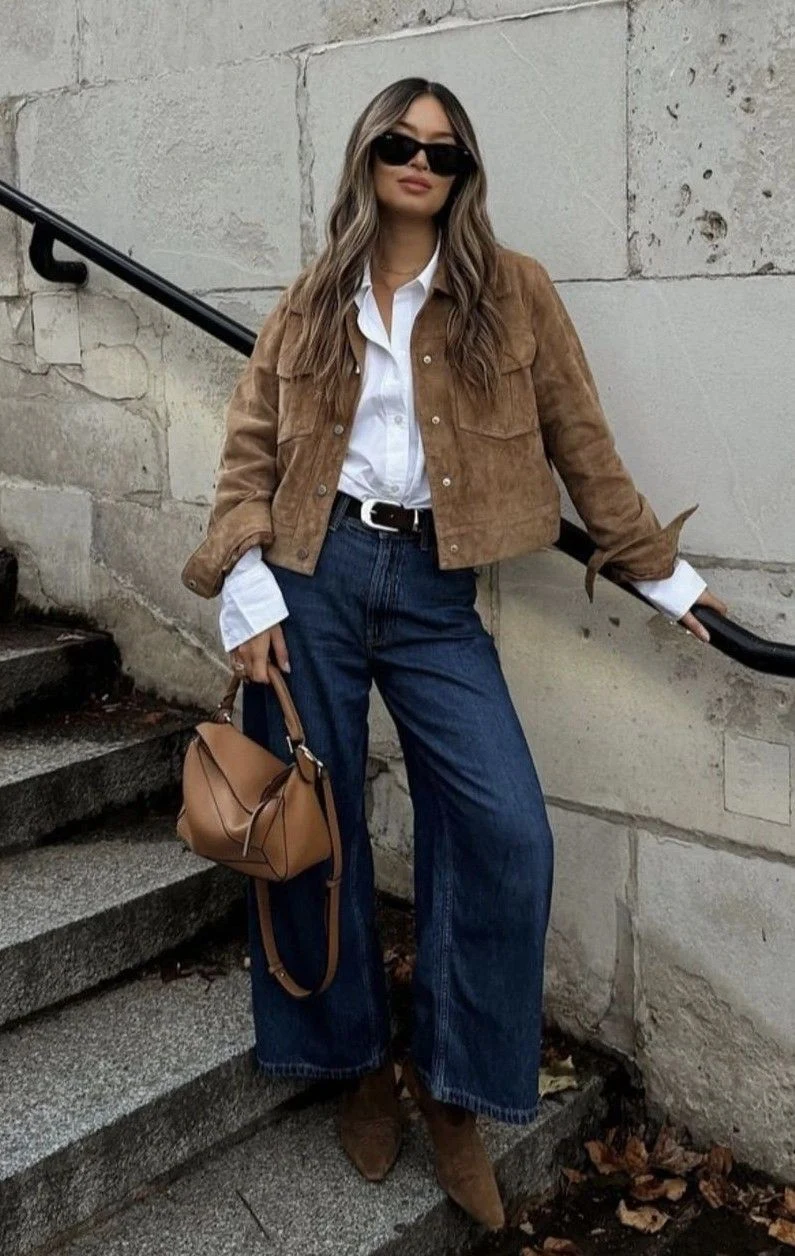 Woman wearing dark wash jeans with cowboy boots and a suede jacket