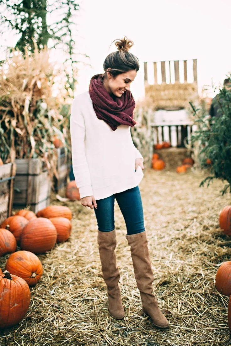Woman wearing jeans with over-the-knee boots and an oversized sweater