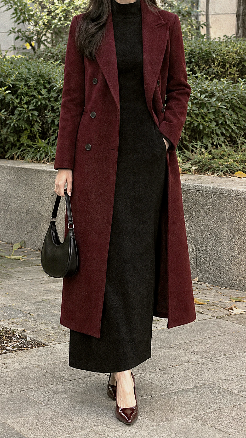 Woman wearing a wine coloured coat over a black dress