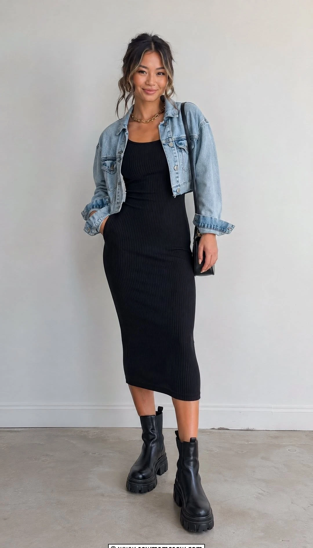 Black ribbed knit dress with a denim jacket and black boots in a studio