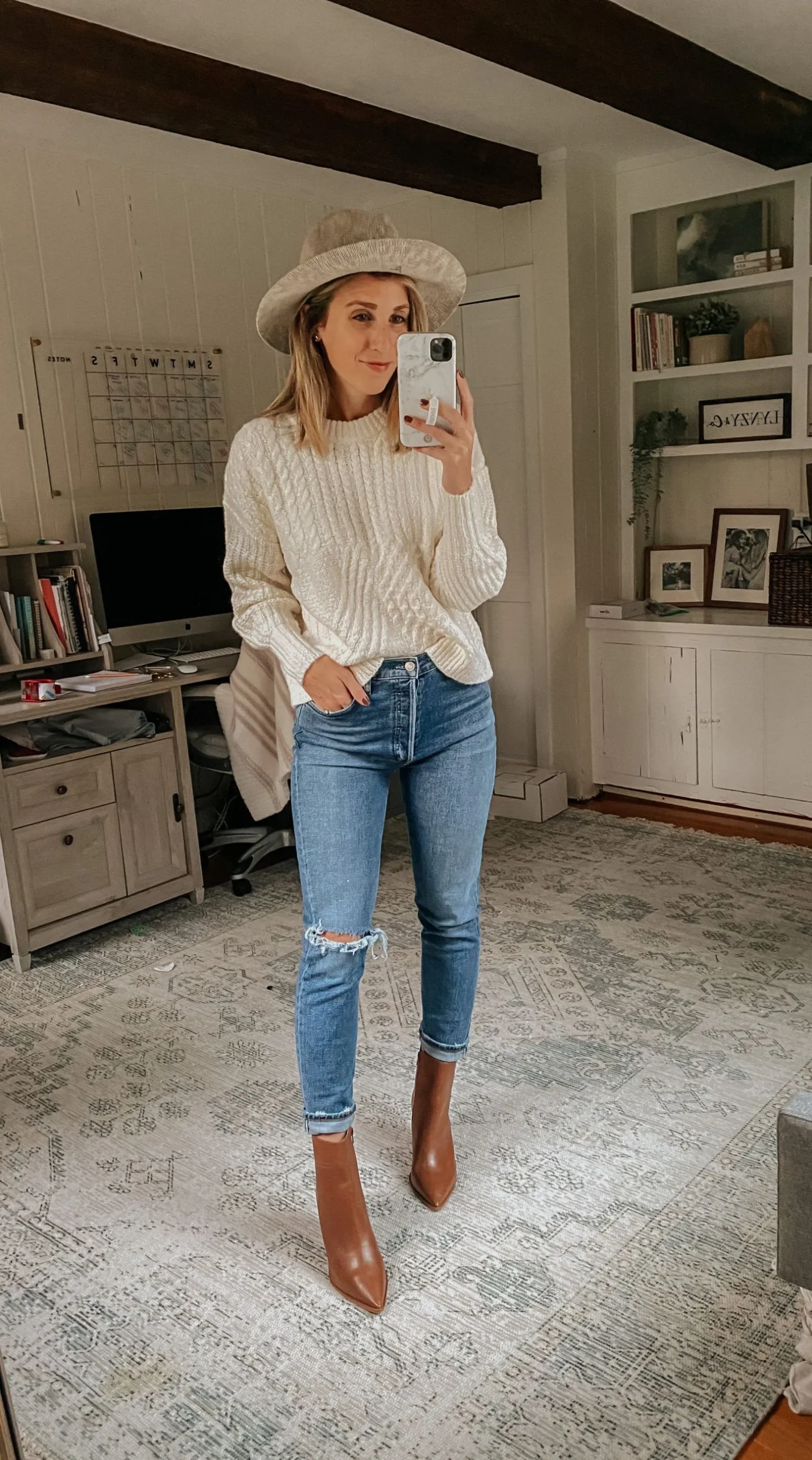 Thanksgiving outfit with cream cable sweater, medium jeans, and brown ankle boots